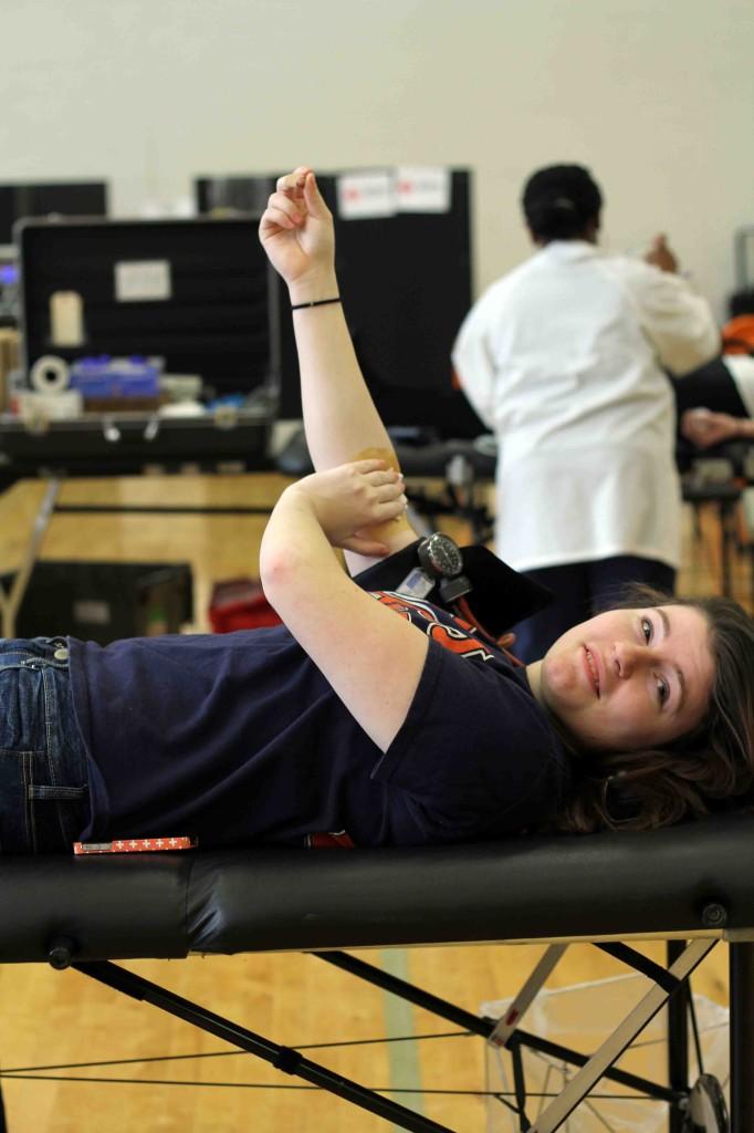 Holding gauze to her arm, senior Amber Bailey finishes up giving blood.