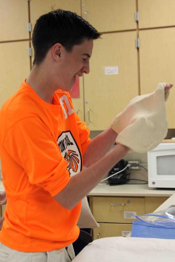Sophomore James Kryza tosses pizza dough for a food lab during Food and Nutrition.