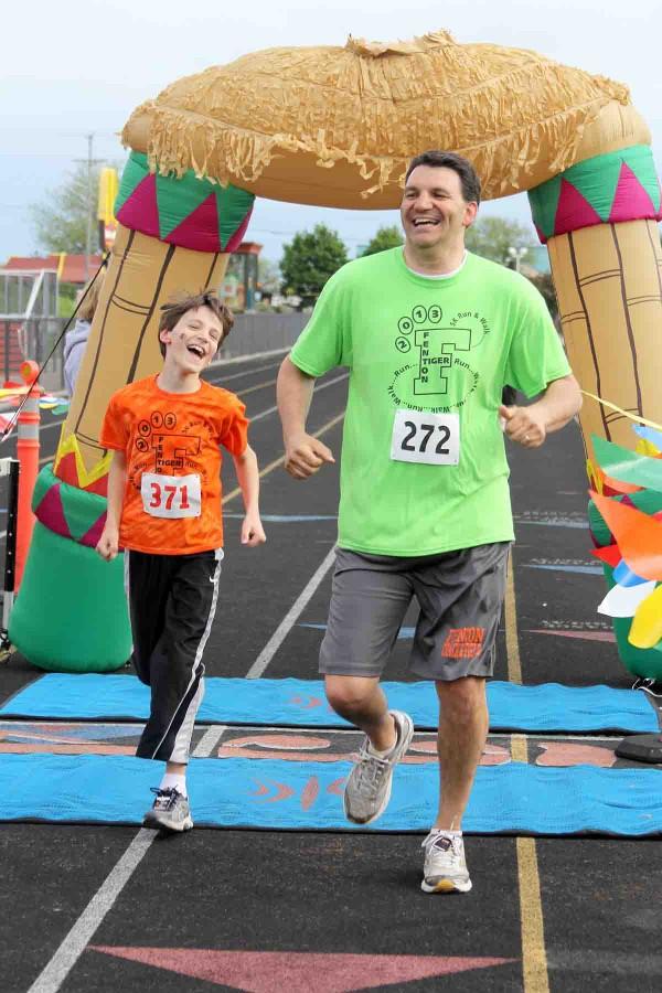 Athletic Director Mike Bakker races his son to the finish line at last year’s third annual Tiger Trot.  The 2014 event will take place on May 17.  Races begin at 8:30 a.m. and will be finished by noon.    