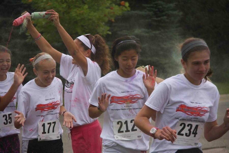 Seniors Kayla Csapo and Emily Battaglia and freshman Abbey Lee run through a cloud of coloring for the Run through the Color and Flames 5K run/walk race. The whole cross country team ran and some people volunteered as well, Csapo said. It was cool that the Fire Hall hosted this event and that we got to participate. Sometimes I will do different races around the community if I have time. Ive done the Fourth of July one a few times, one organized by my friend, and a few others. Proceeds from the race were donated to the Fenton Education Foundation and the Fenton Firefighters Charities.