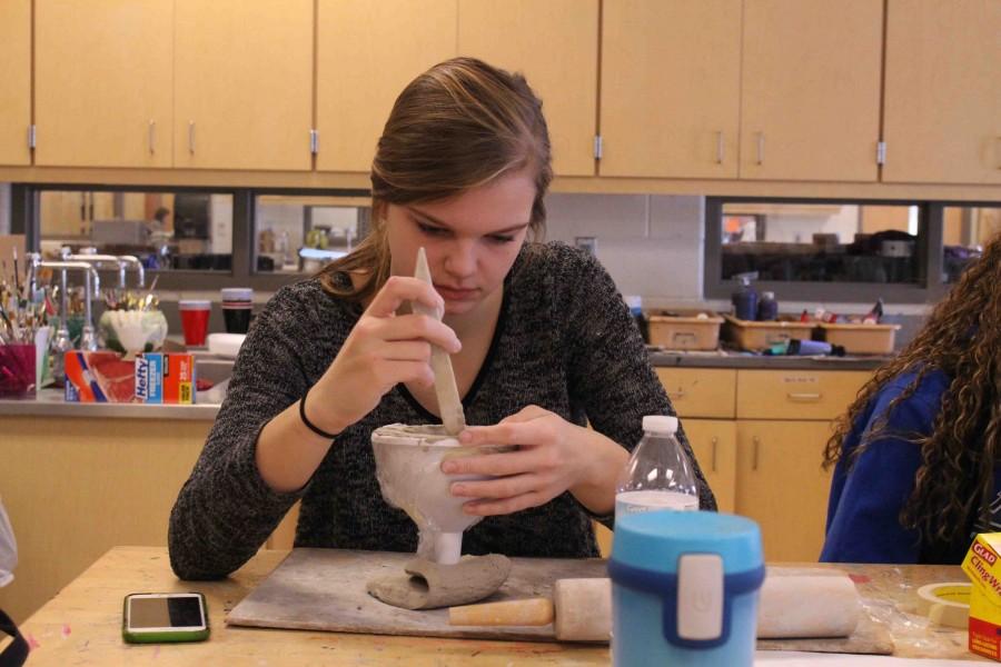 Sculpting the clay, senior Jessie Eastman makes her chalice in her advanced art class. Were making chalices for rootbeer floats in advanced art. We made five different designs and we picked between them. It was kind of difficult to make it stay and hold up the cup, but it was still fun. We still have to paint them.
