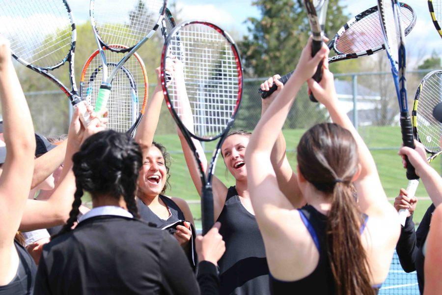 As they hold their rackets up, members of the varsity tennis team cheer after they win their match.  Im currently  two singles and have only been beaten by Holly in the metro league so far, senior Katy Kurncz said. I cant wait to see how I improve from my freshman year of college to my senior year because I worked really hard and dedicated my time to it by going to private lessons, group lessons with girls on my team, and doing Crossfit for strength and conditioning. 
