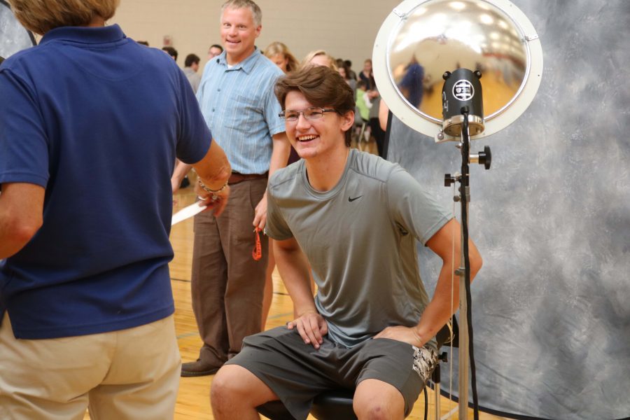 After posing for his third picture day at Fenton High school, junior David Foster cracks a joke with history teacher Matt Place. After amusing the photographer, Foster stood up and let the next person smile into the camera.