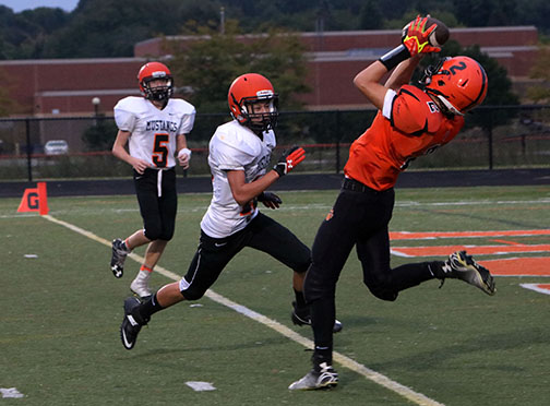 Sophomore, Cameron Steeves jumps to catch the soaring football for Fenton right before scoring a touchdown against the Clio Mustangs on Thursday Sept. 20. The JV team won the game, 54-0. 
