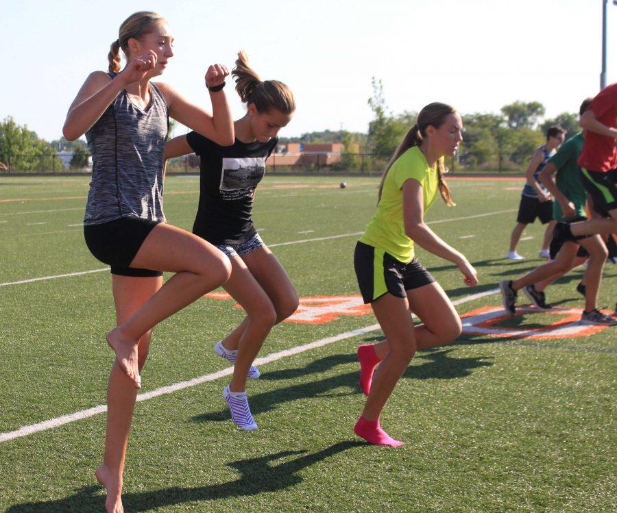 During their 8 AM practice, senior Maddie Johnson and Freshmen Avery Logan and Jessica Adams work out with the rest of their teammates.