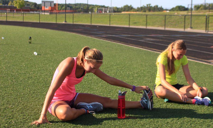 Senior Brenna Bleicher and freshman Jessica Adams stretch and cool down before next work out.