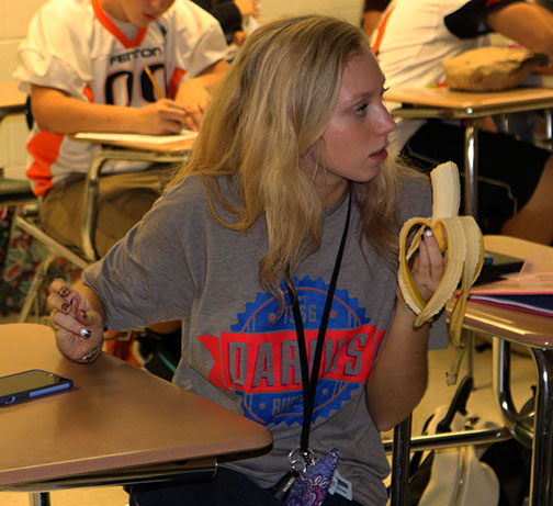 Senior, Samantha Buswell eats a healthy snack during the homecoming party in French teacher Nicole Chouinard’s SRT class on Oct. 6. Students also brought doughnuts and bagels for other students.
