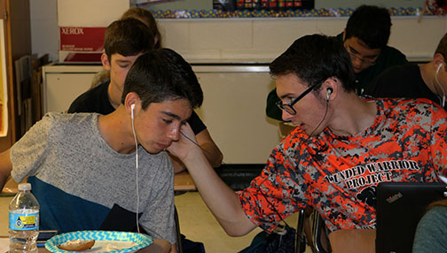 Juniors Samuel Deardorff and Jacob Bellucore listening to each others music during their homecoming party in Mrs. Chouinards class.