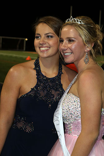Seniors, Elise Cassidy (left) and Taylor Mowery (right) pose for a picture after Mowery was crowned Homecoming Queen at the game vs Flushing.