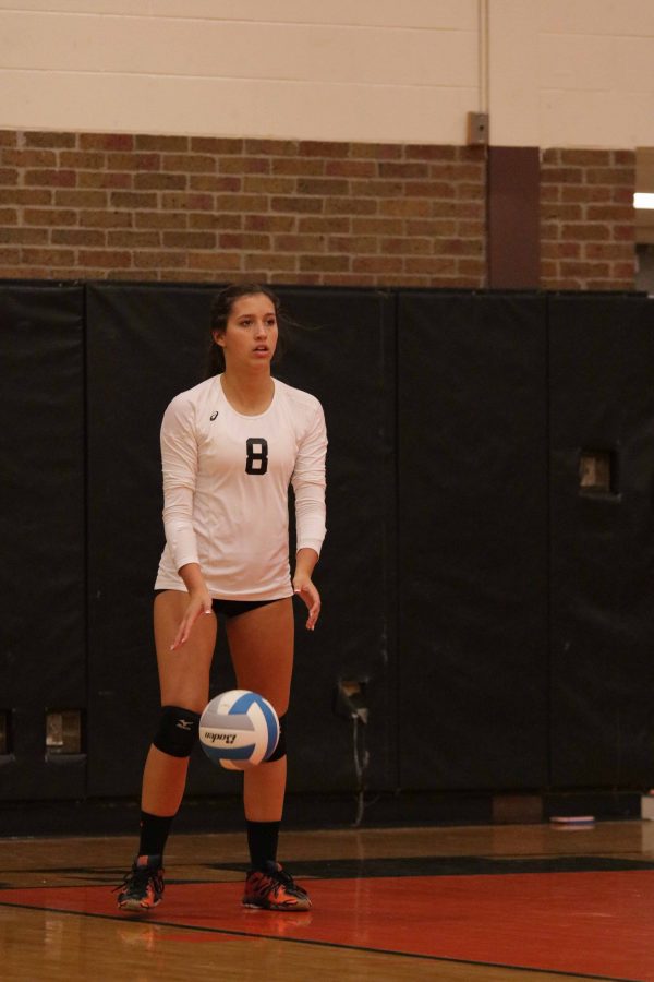 Junior Libby Carpenter prepares to serve the volleyball at the Flushing game on Oct. 11.