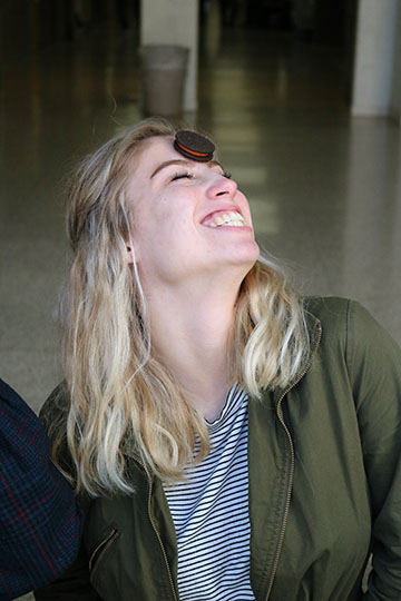 Laughing while trying to accomplish the “Face the Cookie” challenge in first lunch. Junior, Kasey Caswell joins the lunch games to promote the yearbook before the price goes up. Caswell tries to move the cookie down her face and into her mouth without dropping it.