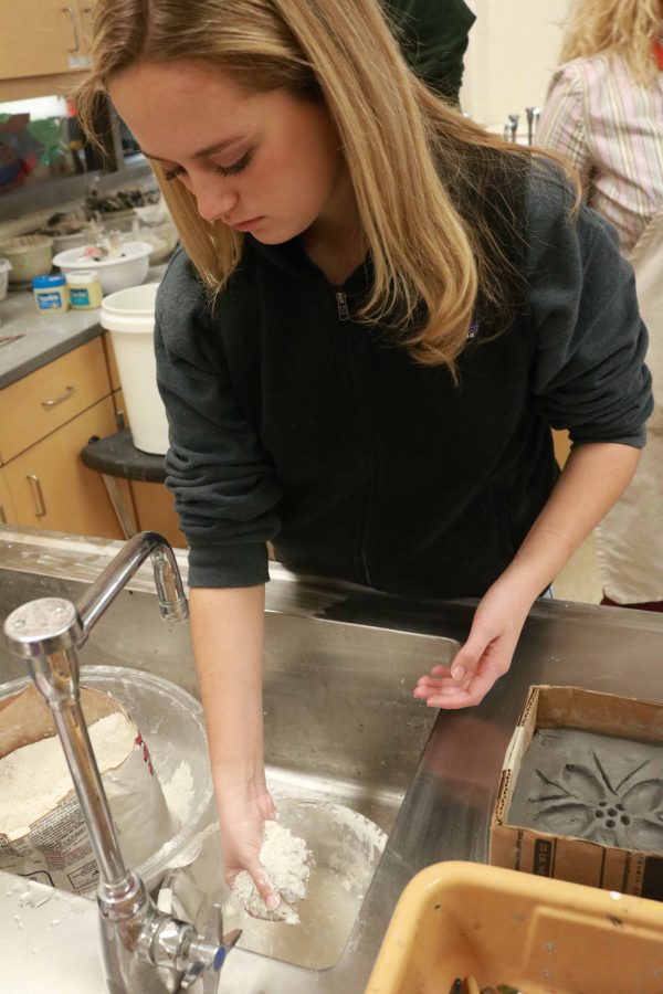 At the beginning of Mrs. Mosss 1A sculpture class, sophomore Grace Shepard grabs plaster to mix into the water. Once her plaster is mixed, she poured it on top of her clay mold. 