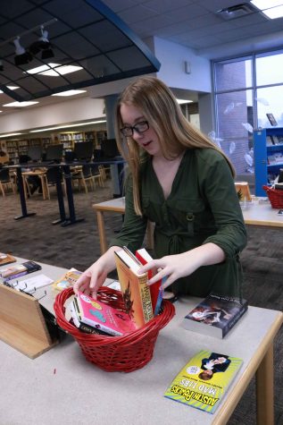 During her media service class, sophomore Jenna Thornton straightens up the book fair that was taking place in the library. 