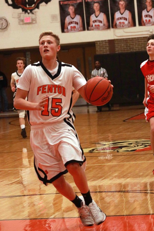 Sophomore Chase Poulson dribbles the basketball towards Fentons basket during the Holly game on Jan. 13.