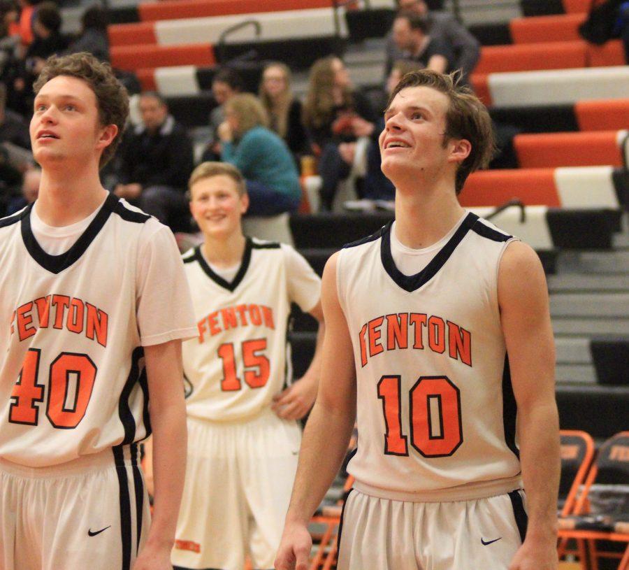 Sophomores Logan Welch, Chase Poulson, and Liam Hillis smile during a successful free throw during the Clio game on Jan. 24.