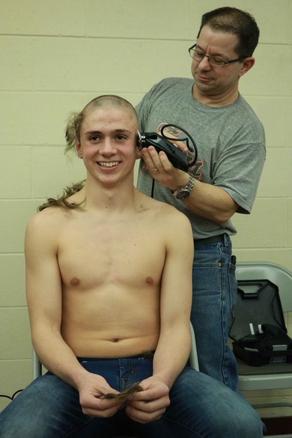 To prepare for their Metro swim meet freshman Ben Sheffield gets his head shaved by his swim coach Brad Jones. The team had a pasta party on Thursday night to carb load and shaved their heads for the big weekend ahead. 