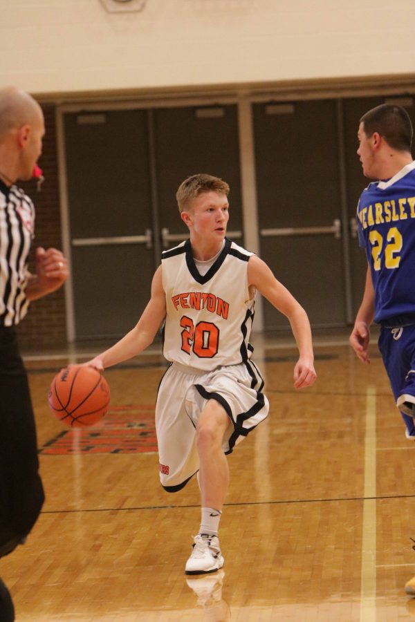 Sophomore Nolan Day races down the court with the ball while playing Kearsley on Feb. 9.