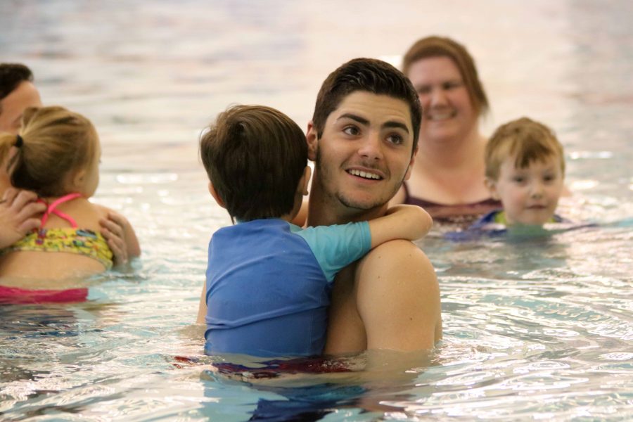 Swimming with the kindergarten class, senior Patrick Conroy smiles at the instructor.
