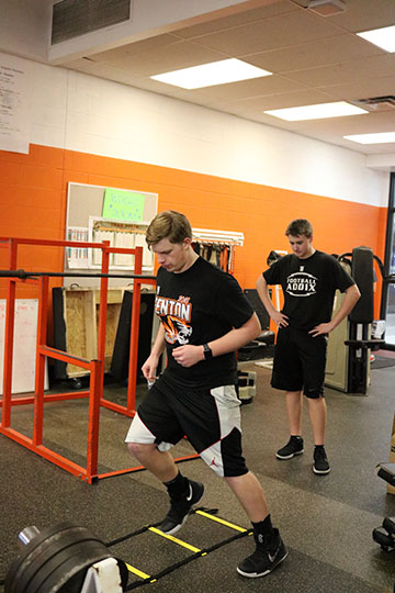 Freshman Zach Schulz getting ready for next years football season by doing reps at the ladder station.