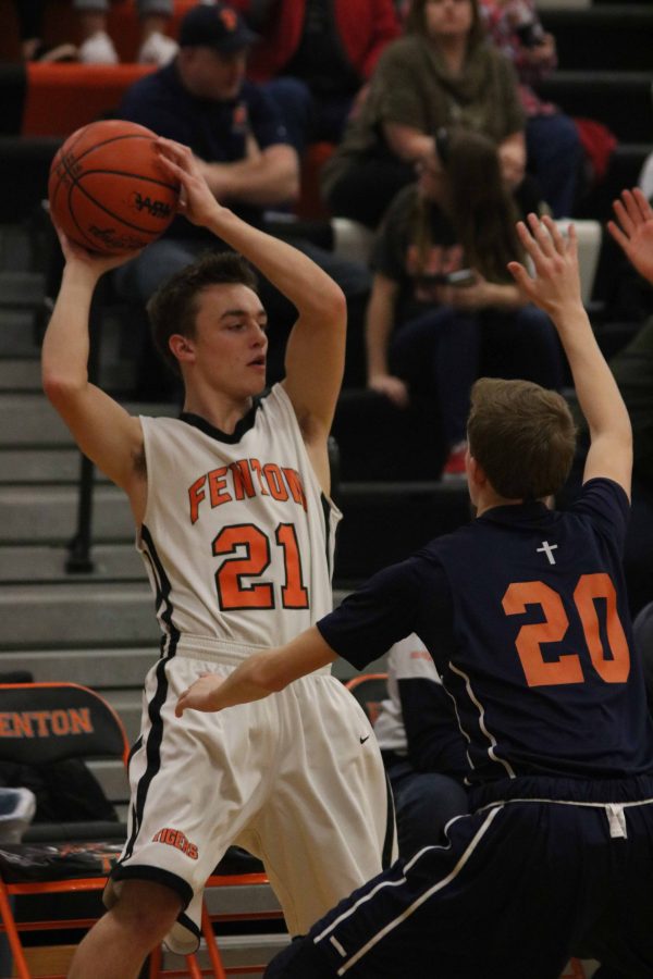 Sophomore Brock Henson waits for a teammate to get open while protecting the basketball.  The game was on Feb. 28 against Flint Powers Catholic School, Fenton lost 49-46.