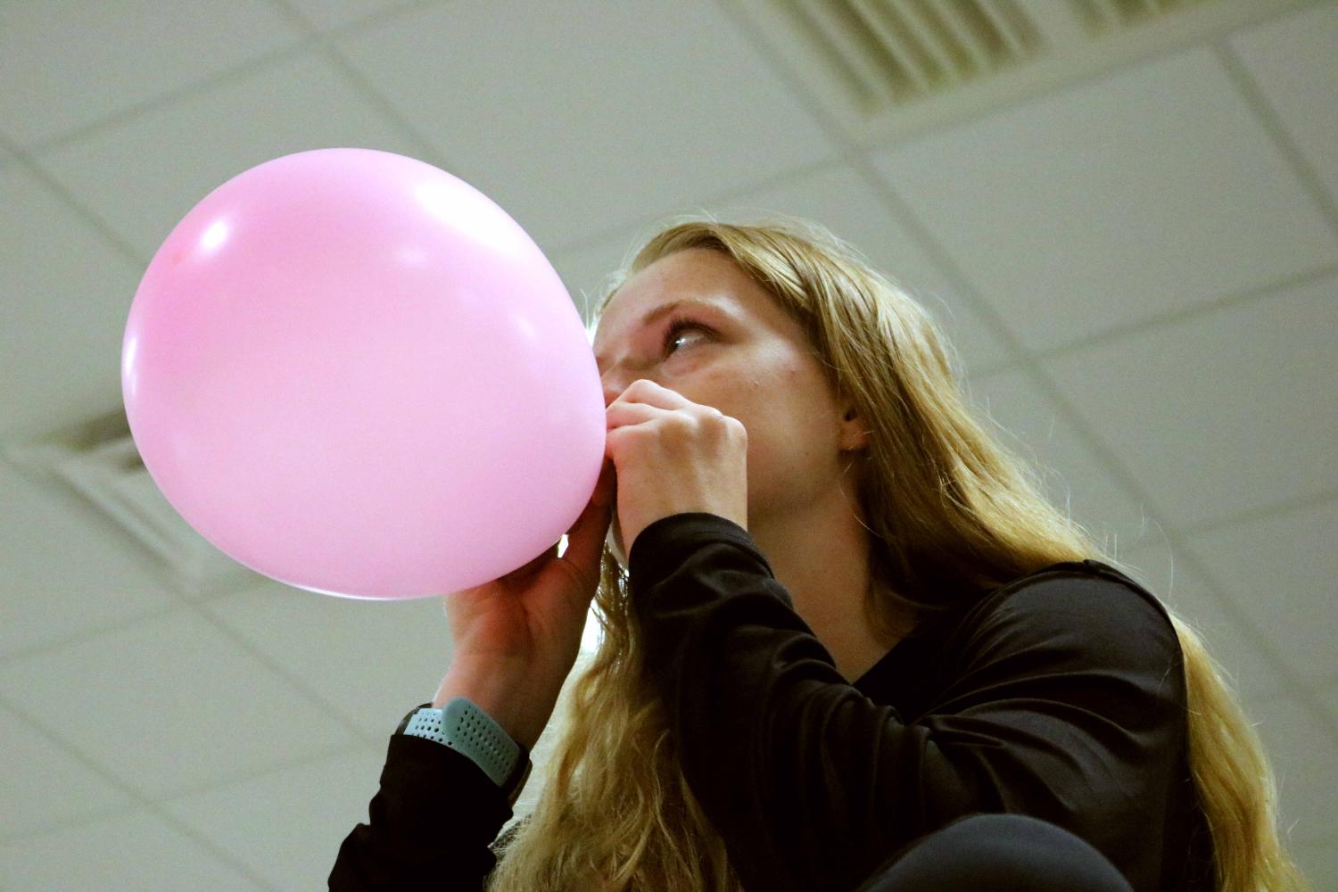 Blowing up a balloon, senior Jenna Keiser helps her fellow SRT seniors do something for Mr. Wright. As a parting gift, they spent most of Tuesday morning filling his office with balloons. 