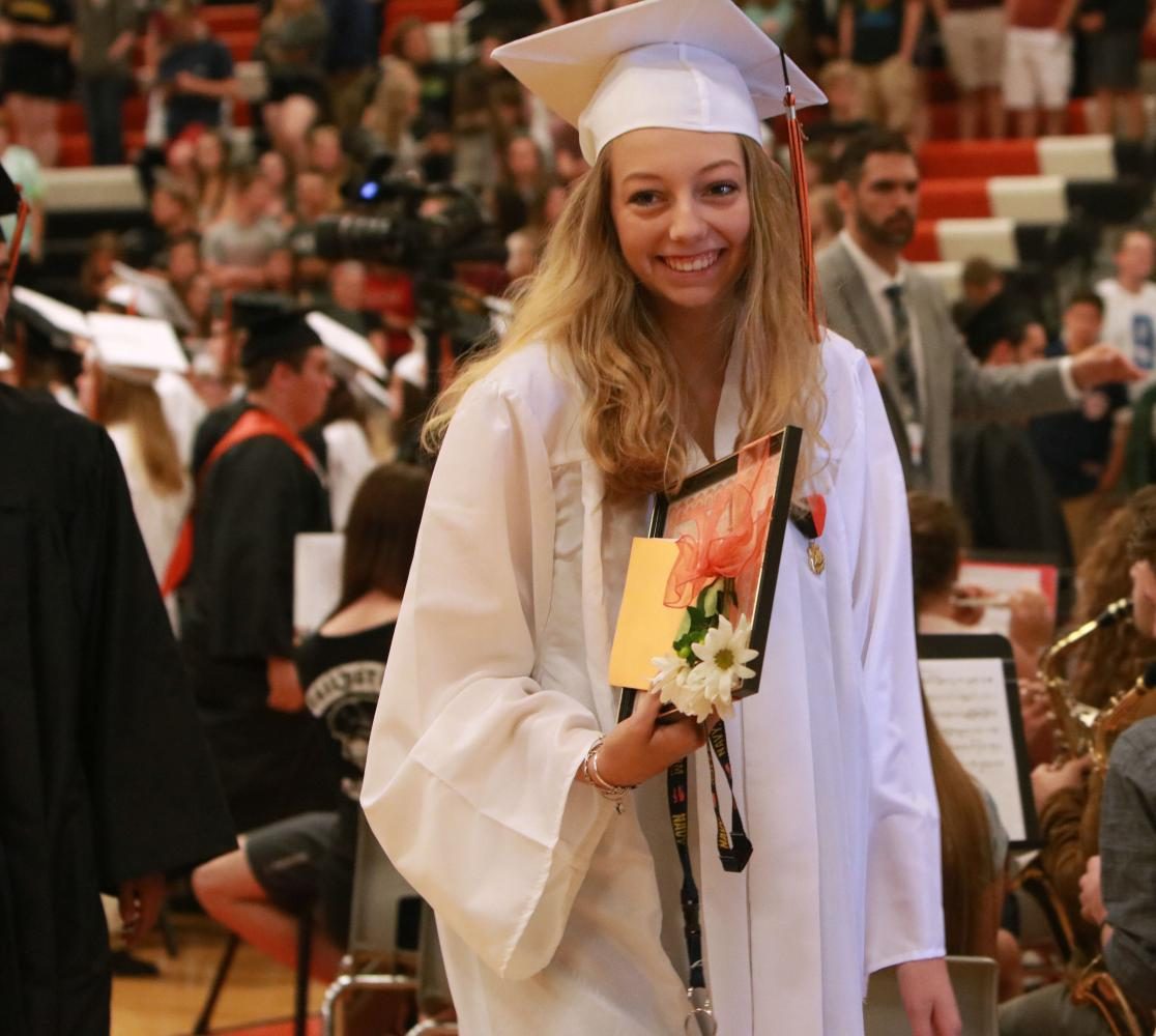 Senior Erica Kolanowski smiles at the camera as she is walking out of the gymnasium to greet her friends and family members for her academic achievements. Kolanowski and the rest of the class of 2017 gathered at the Fenton High gymnasium on June 9 to celebrate the moment they all have been waiting for four years. 