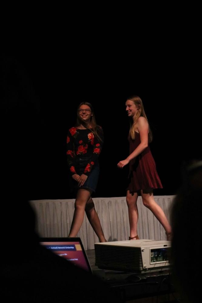 Seniors Maddie Janowak and Emma Cagle walk down the stage as they receive a scholarship.  The scholarship assembly honors eligible seniors by rewarding them with a scholarship for the next chapter of their life.