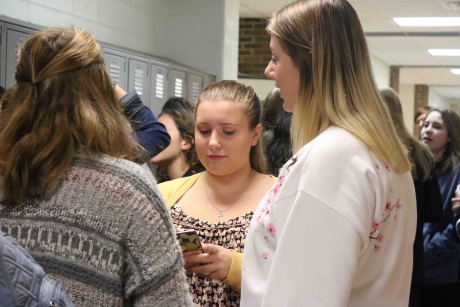 Sophomore Lillian Thompson checks her phone as she waits in line for the Marching Band breakfast. Every year the Marching Band hosts a breakfast for its members as a gift for all the hard work and time they put in.