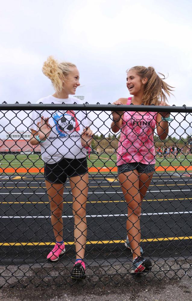On October 4, juniors Abbey Lee and Cami Tieman stretches their legs to prepare to run. The cross country team ran around town then came back to do more workout. 
