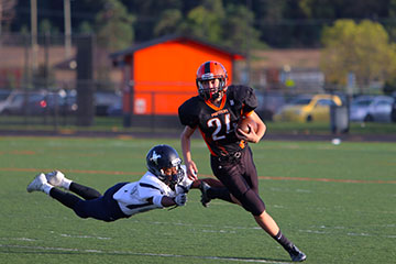 Outrunning his opponent Brandon Miller, heads towards the touchdown zone. The Fenton Freshman boys lead the game with a score of 42 and Mott Waterford with 28.