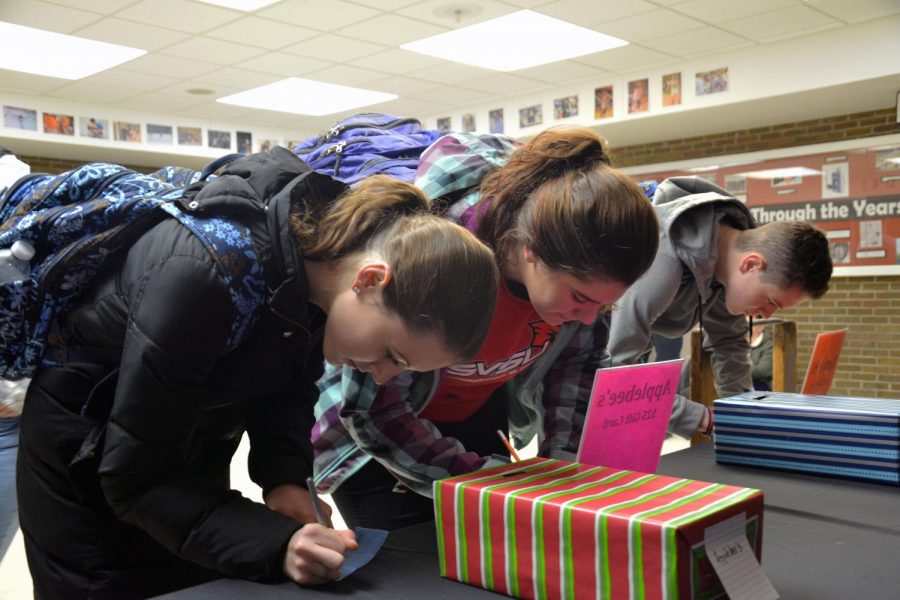 Having brought in a canned good for the Hunger Hoopla, senior Delany Hundzinski fills out her ticket for a chance to win one of four gift cards for local restaurants. This year key club collected enough canned goods to fill the stage at word of wonder.