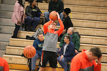 Shooting the ball during warm-up, Junior Logan Welch prepares himself to play against Kearsley. Welch and his team played hard and beat Kearsley with the score of 65-60.