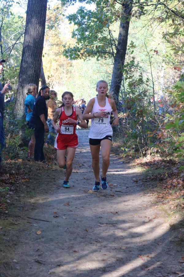 Keeping the lead, sophomore Alexa Keiser runs as a competitor trails behind her.