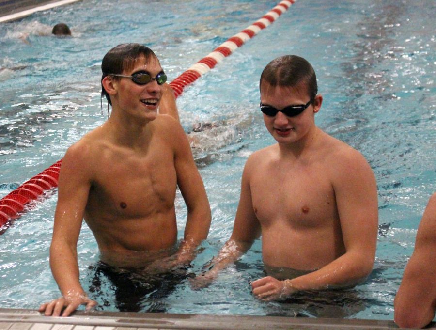 In between sets, junior Jake Iddings and freshman Alec Maddock take a break and chat with teammates. Varsity swim compete next on Feb. 22 and 23 at home.