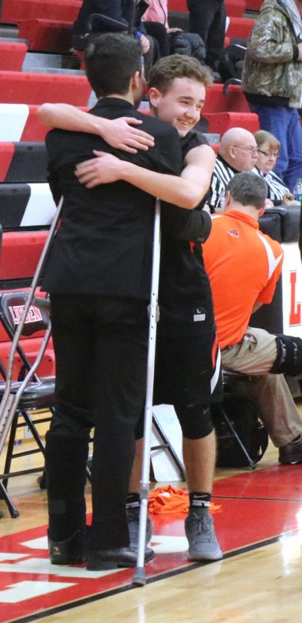 Sophomore JP McArdle hugs his teammate at the end of a victorious game. The JV basketball team beat Linden on Jan. 18, continuing their season with pride. 