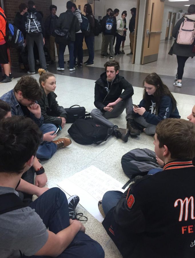 Students sit in the square in a silent protest on Feb. 21. They were stationed in the square to protest against gun violence. 
