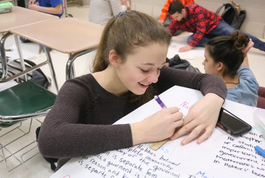 Freshman Hannah Ludwig works on her poster for Honors World History. On Feb. 2, students made posters for enlightenment thinkers, preparing to present them to the class. 