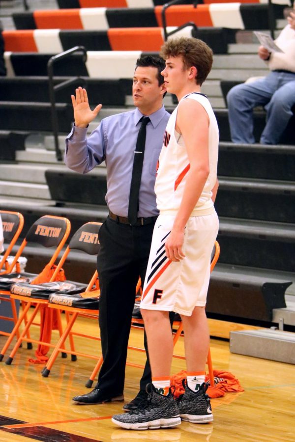 Receiving advice from his coach, sophomore Luke Curren listens to his coach to know what he will need to do when he goes back in. The JV boys basketball played a strong game where they beat Clio.