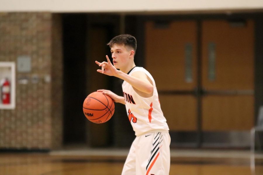 Dribbling the ball down the court, sophomore Trent Degayner giving a signal to his team for their play. The Varsity Boys basketball team played their last game March 1st against Milford.  