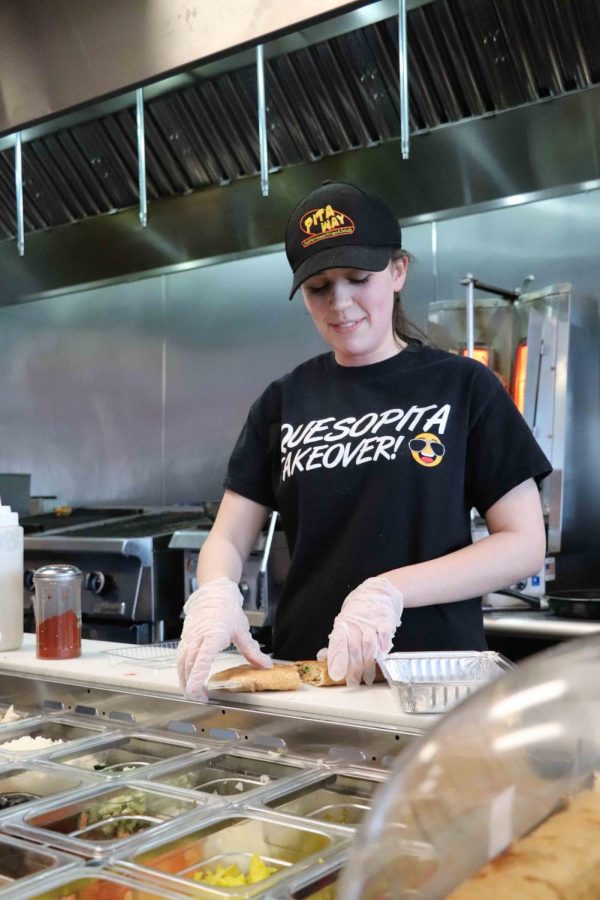 Junior Alyssa Lawrence prepares a chicken shawarma quesopita for her customer. Lawrence works as a cashier at Pitaway in Fenton. 