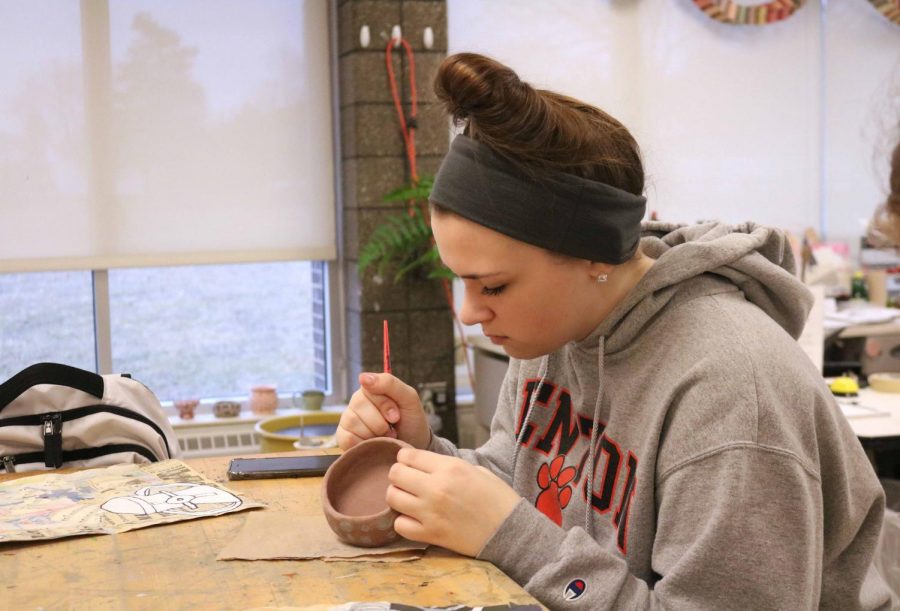 Junior Alaina Russo, works on her sgraffito bowls in her art class. The art students were asked to make bowls and paint an iron oxide slip over them and then to scratch through the slip layer to create a pattern, these bowls will be sold at the art show held at AGS middle school.