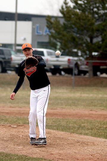 Catching the ball, Freshman Jake Wohlfert pitches for his team.  The boys played a double header winning the first game 12-2 and  cancelling the second due to the rain.