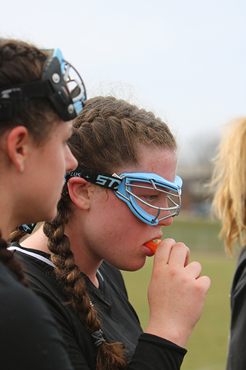 During a time out, freshman Kyla Lynch listens to her coach. The girls varsity lacrosse team beat the Swartz Creek Dragons 13-3.