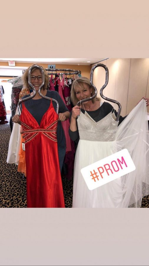 Volunteers and young ladies hold up dresses donated to ROCKit. 