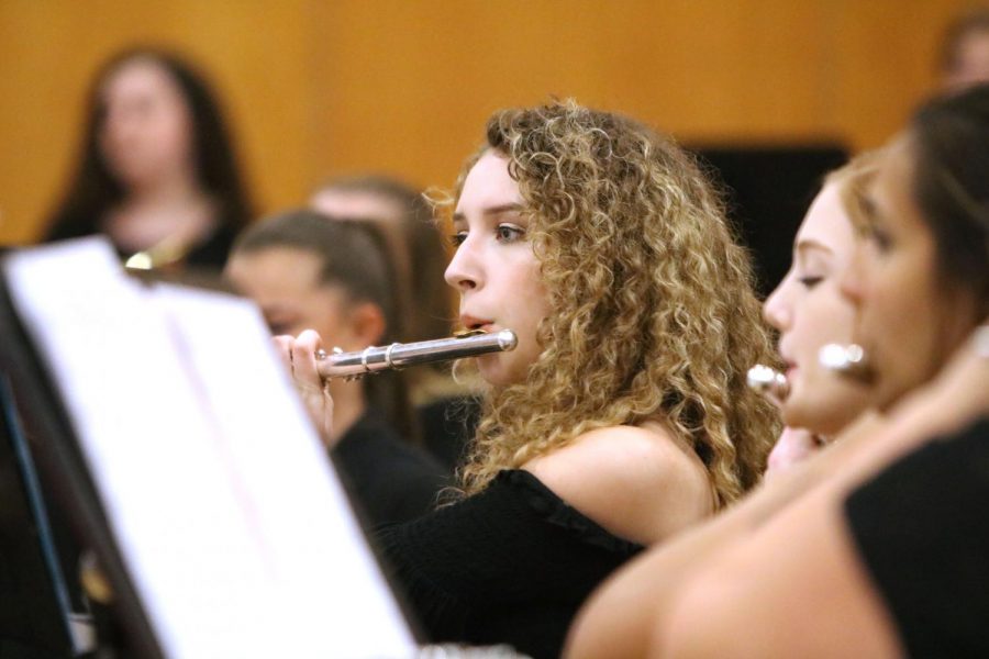 Sophomore Layla Ike reads her sheet music as she plays her flute during the spring band concert. Band students performed for family and friends with  student teacher Henry Pakela conducting. 
