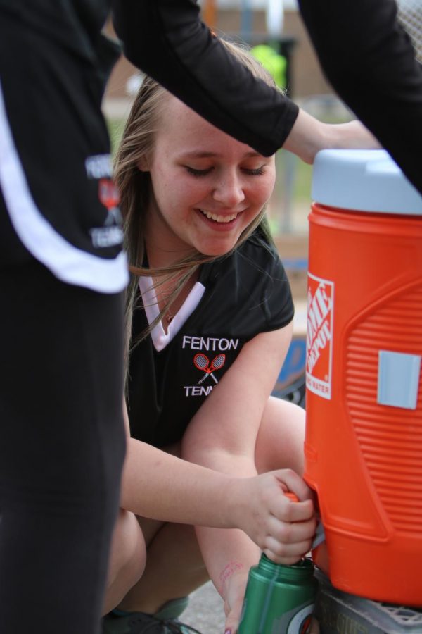 Smiling+while+filling+up+water+bottles+before+there+game%2C+freshman+Liz+Donohue+prepares+for+the+match+against+Kearsley.+As+the+warm+weather+set+in%2C+the+Fenton+JV+tennis+team+fell+to+Kearsley+on+April+20th%2C+losing+6-2.+