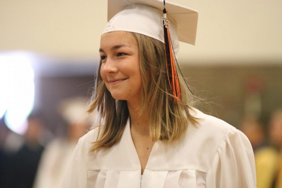 Walking to her seat, senior Lucy Meuch participates in the senior honors assembly with the rest of her class. Every year the seniors get honored in a school wide assembly for their achievements throughout their high school career.