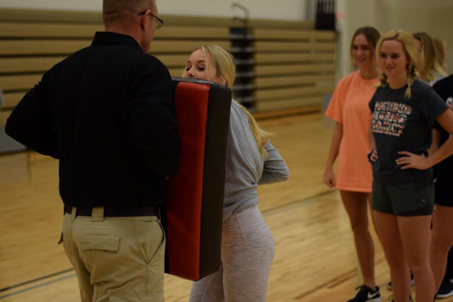 Officer Tom Cole teaches senior Tori Fitzgerald self defense. Cole taught self defense tactics to all girls fitness classes. 

