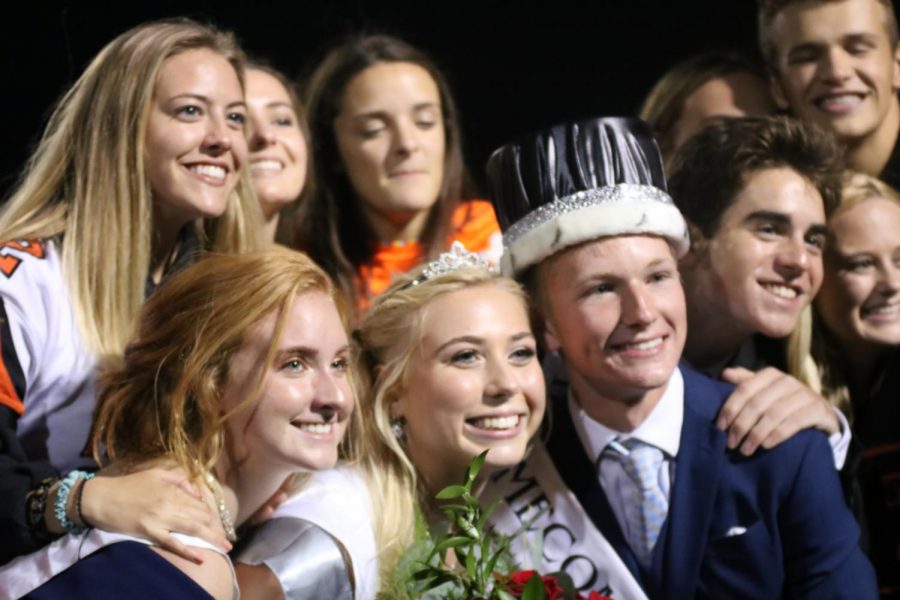 Seniors Chloe Idoni and Nolan Day pose for a photo with their friends after being crowned homecoming King and Queen. The pair were crowned by former students Ari Mansour and Josh Maher at the homecoming game on Friday, Sept. 21. 