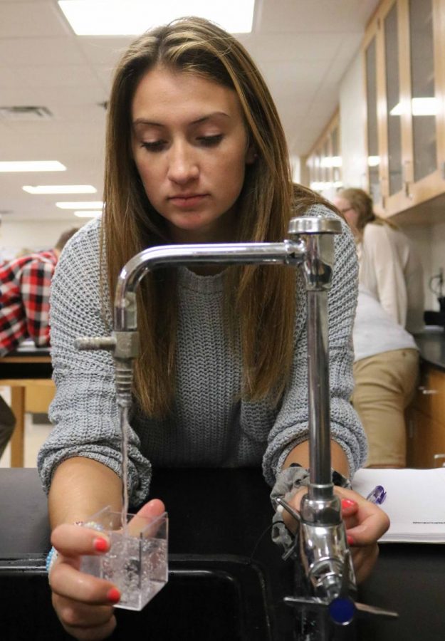 While the members in her group were getting other materials for their lab, junior Lily McKee turns the water on to measure the volume of a cube. On Sept. 10, students in Chemistry began to conduct their volume lab.